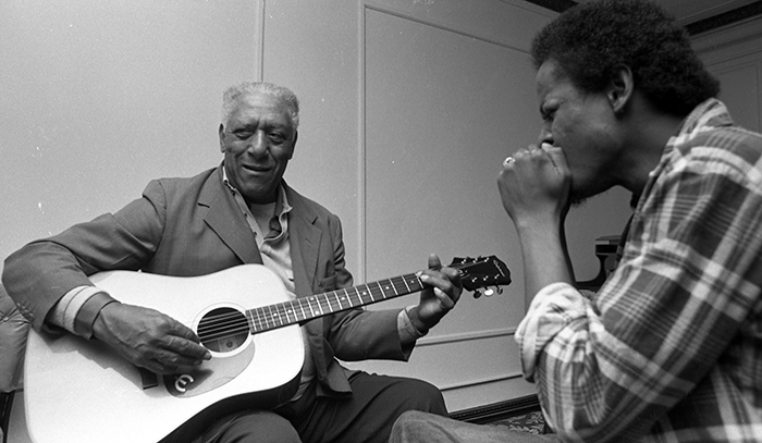 musicians playing guitar and harmonica