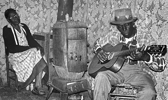 musician playing guitar, woman listening