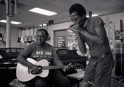 musicians playing guitar and harmonica