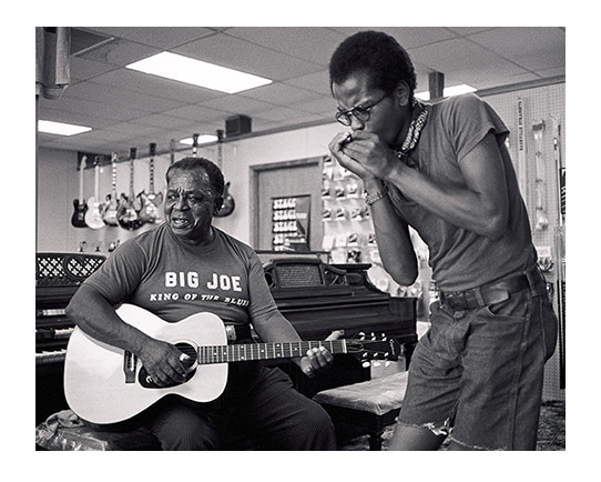 musicians playing guitar and harmonica