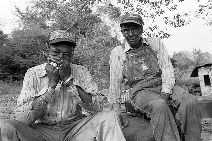 2 men, one playing harmonica