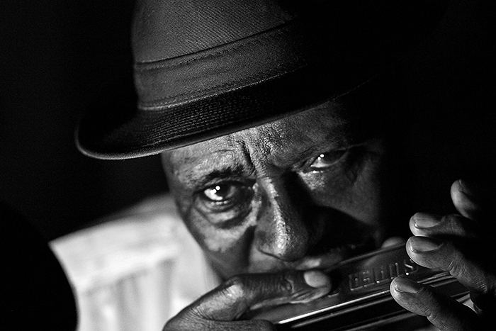 manplaying harmonica