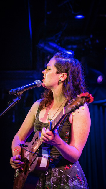 Woman singing and playing guitar