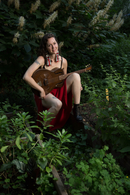 Woman outside with guitar