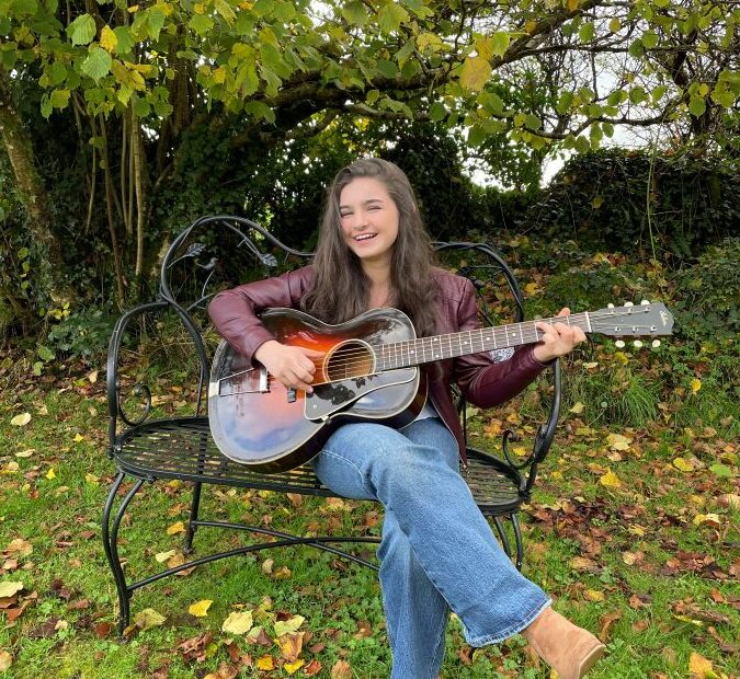 Muireann Bradley with guitar outdoors